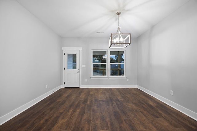 unfurnished dining area featuring baseboards, visible vents, dark wood finished floors, and a chandelier