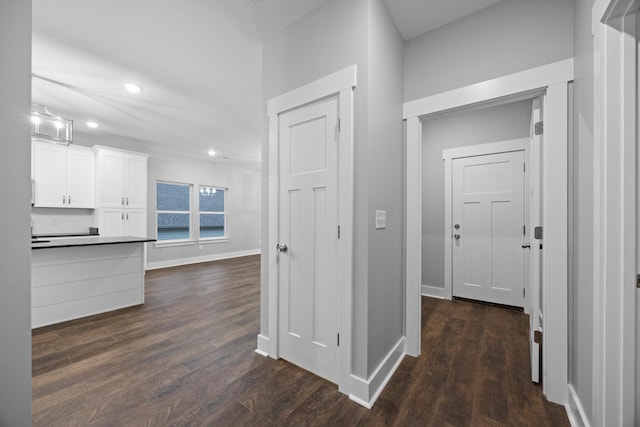 hallway with recessed lighting, dark wood-style flooring, and baseboards