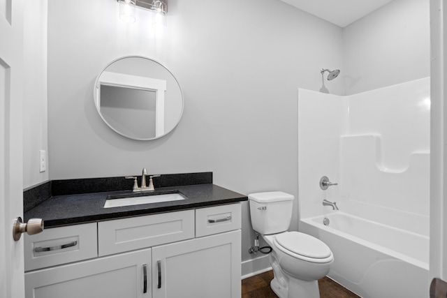 bathroom featuring vanity, wood finished floors, toilet, baseboards, and washtub / shower combination