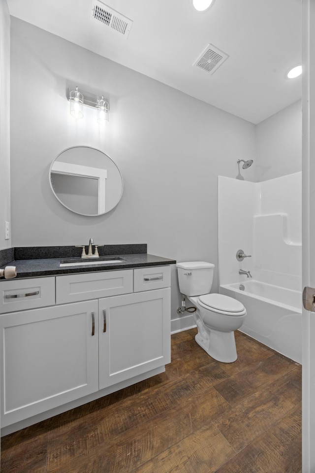 full bathroom featuring visible vents, washtub / shower combination, toilet, and vanity