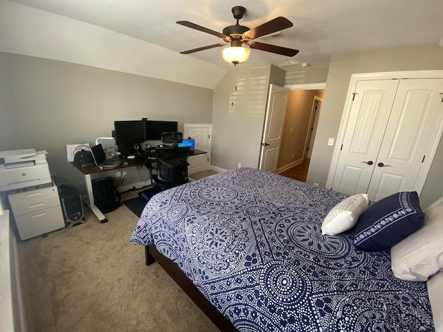 carpeted bedroom with ceiling fan, lofted ceiling, and a closet
