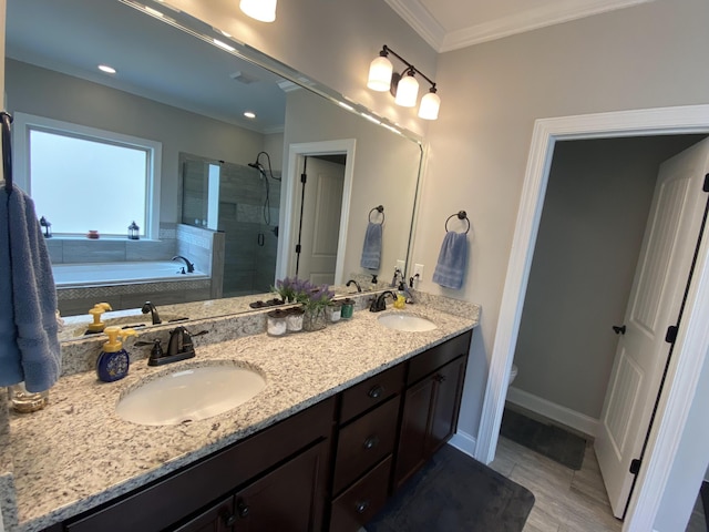 full bathroom featuring a bath, a stall shower, ornamental molding, and a sink