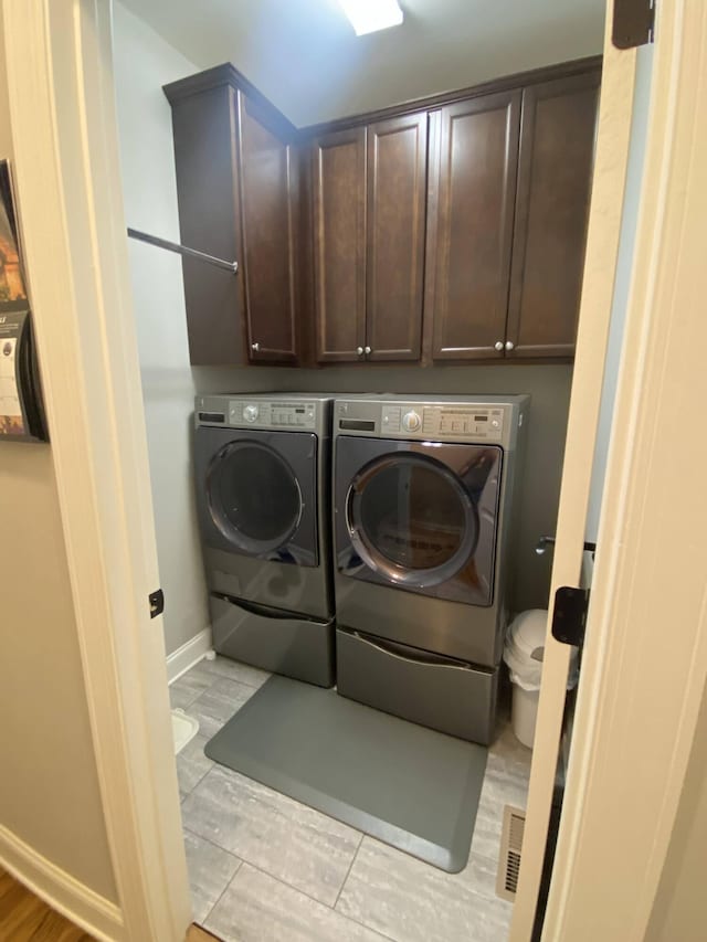 laundry area featuring baseboards, washer and dryer, visible vents, and cabinet space