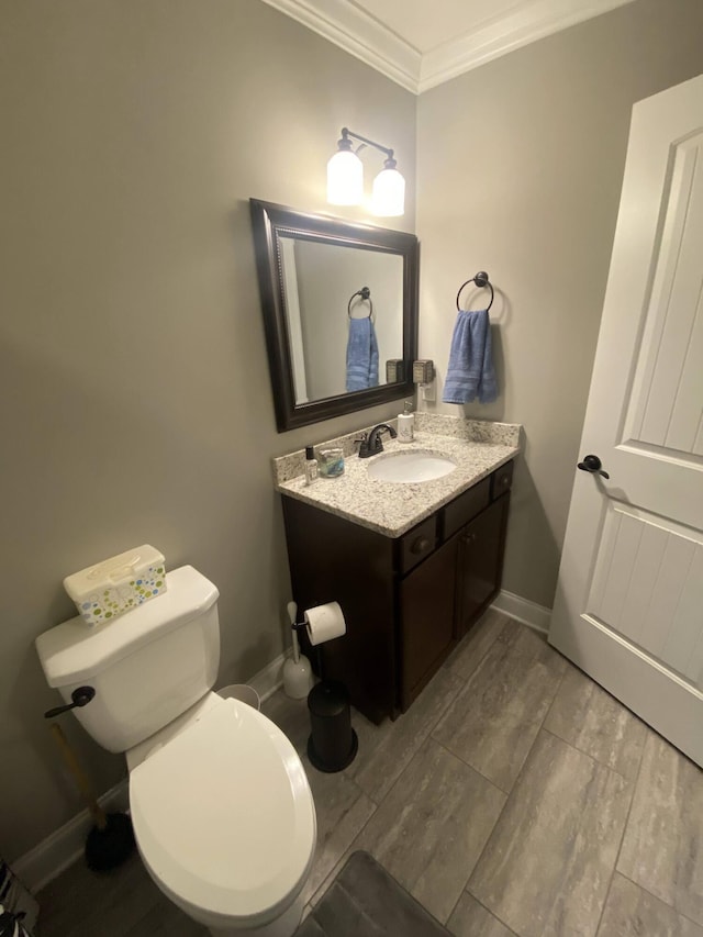 bathroom featuring crown molding, toilet, wood finished floors, and vanity