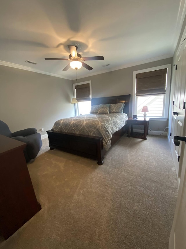 bedroom featuring a ceiling fan, crown molding, visible vents, and carpet floors