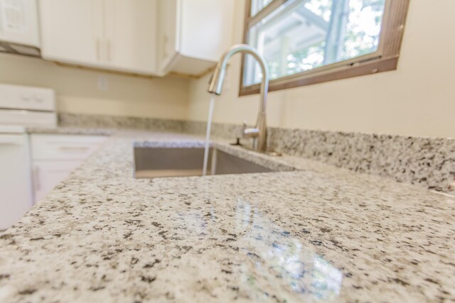 229 General Thomas St, Chickamauga, GA 30707 - kitchen view of range, white cabinetry, a sink, and light stone countertops