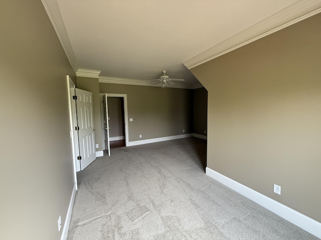 carpeted spare room featuring ceiling fan, baseboards, and ornamental molding