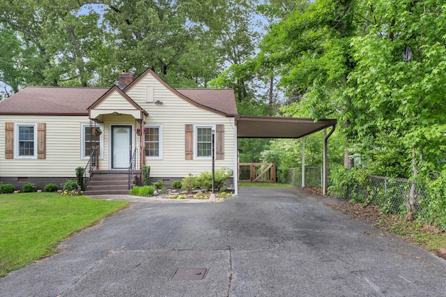 view of front facade featuring crawl space, driveway, a chimney, a front yard, and fence