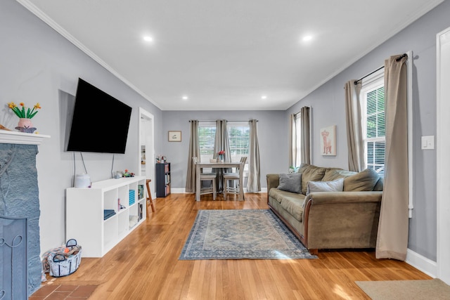 living area featuring baseboards, ornamental molding, recessed lighting, and wood finished floors