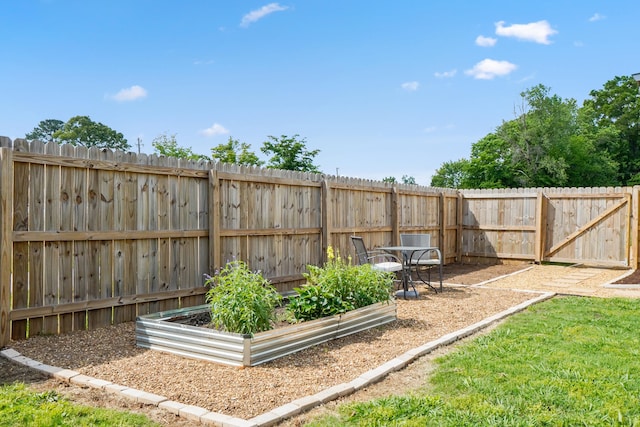 view of yard featuring a fenced backyard and a garden