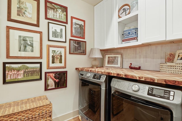 laundry room featuring baseboards, cabinet space, and washer and dryer