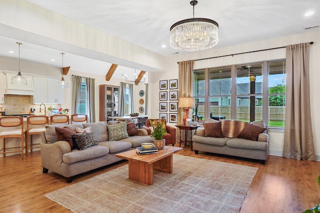 living room with visible vents, baseboards, light wood finished floors, a notable chandelier, and recessed lighting