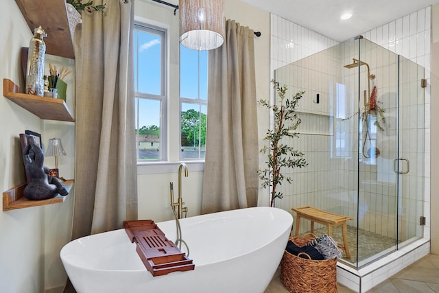 bathroom featuring a soaking tub, a wealth of natural light, and a stall shower