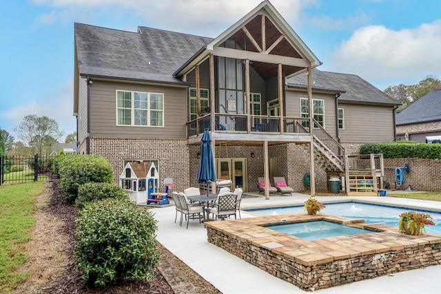 2025 Enclave Dr, Rocky Face, GA 30740 - back of property with a patio area, brick siding, stairway, a wooden deck, and an in ground hot tub