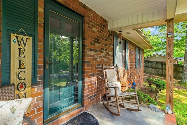 4042 Village Dr, Cohutta, GA 30710 - property entrance featuring a porch, brick siding, and fence