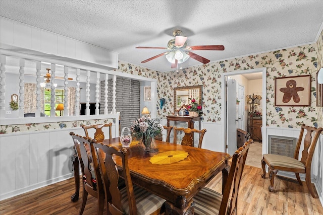 4042 Village Dr, Cohutta, GA 30710 - dining area featuring a wainscoted wall, wood finished floors, a textured ceiling, a ceiling fan, and wallpapered walls