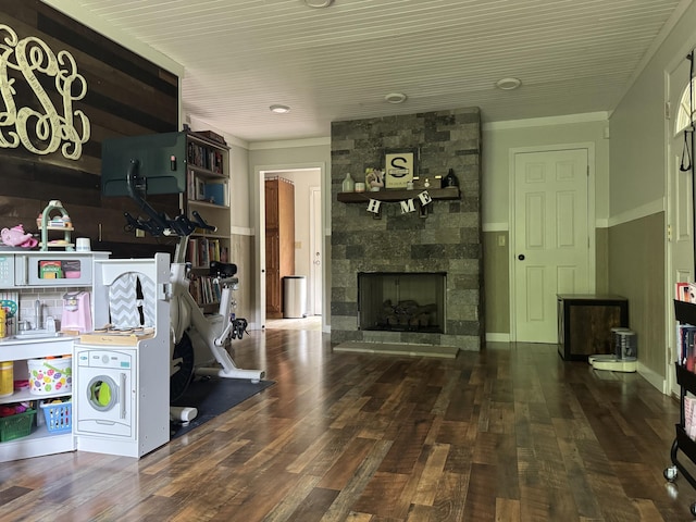 living room with a fireplace, crown molding, and wood finished floors
