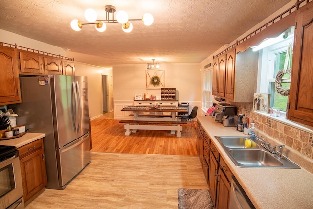 2752 Swanson Rd, Ringgold, GA 30736 - kitchen featuring a sink, light wood-style floors, brown cabinetry, a textured ceiling, and light countertops