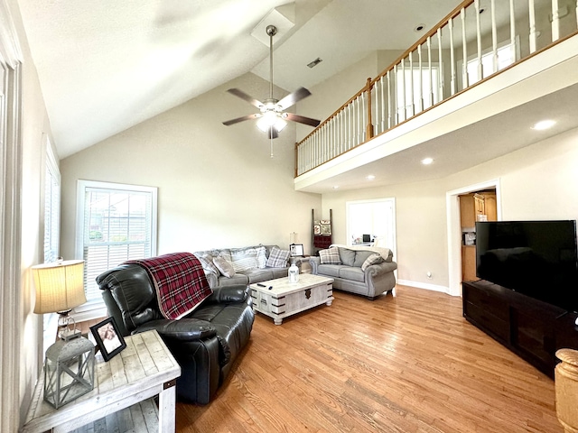 living area featuring wood finished floors, a ceiling fan, high vaulted ceiling, visible vents, and baseboards
