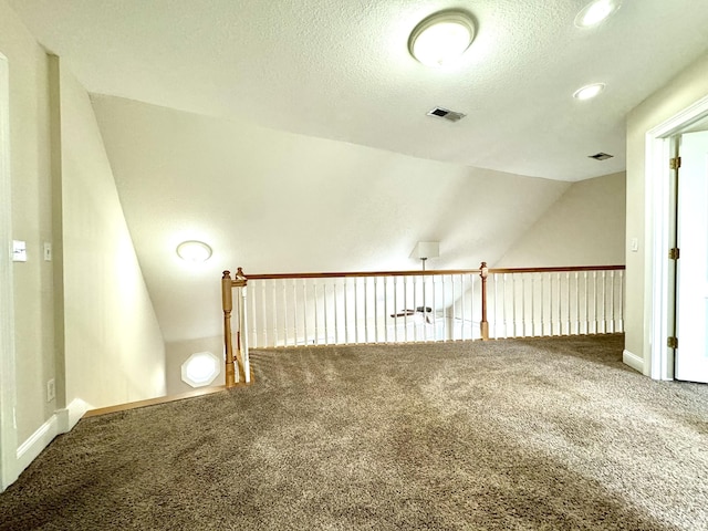 bonus room with baseboards, a textured ceiling, carpet floors, and vaulted ceiling
