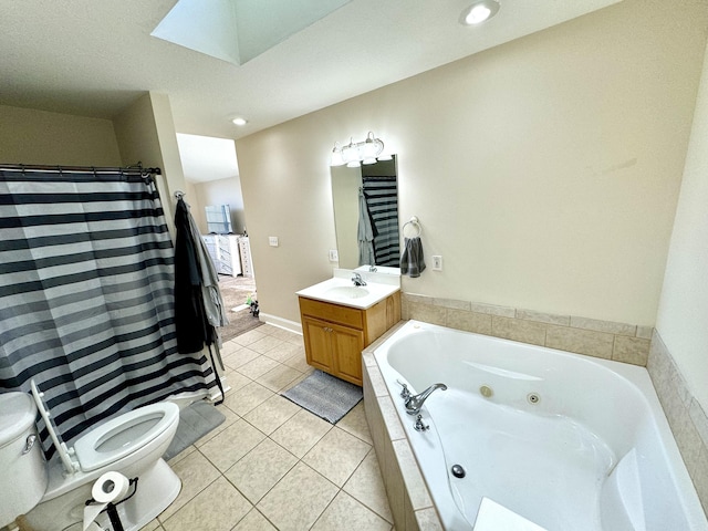 full bathroom featuring toilet, tile patterned flooring, a jetted tub, vanity, and a skylight