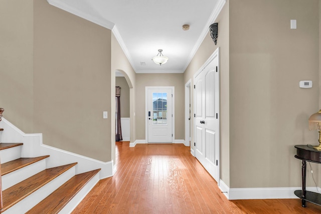 8358 Front Gate Cir, Ooltewah, TN 37363 - foyer entrance featuring ornamental molding, light wood-style floors, arched walkways, baseboards, and stairs