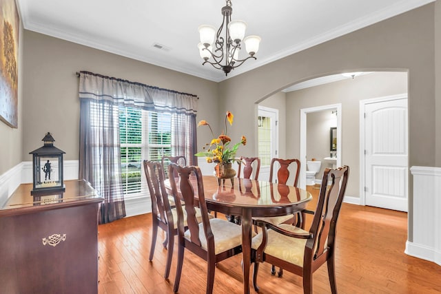 8358 Front Gate Cir, Ooltewah, TN 37363 - dining area featuring arched walkways, light wood-style floors, a chandelier, and crown molding