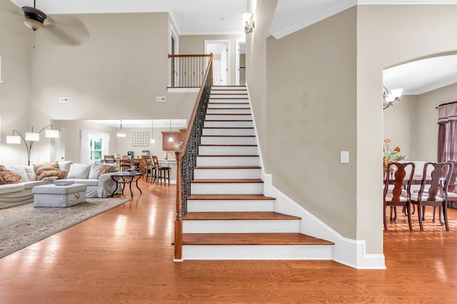 8358 Front Gate Cir, Ooltewah, TN 37363 - stairs with wood finished floors, a ceiling fan, crown molding, and arched walkways