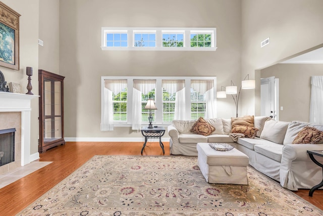 8358 Front Gate Cir, Ooltewah, TN 37363 - living area featuring a towering ceiling, a fireplace, wood finished floors, and baseboards