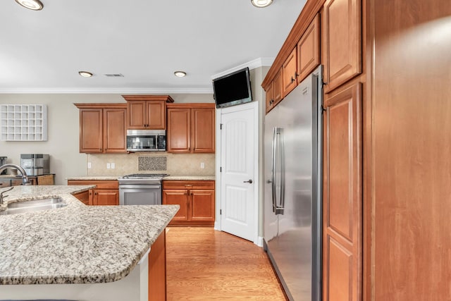 8358 Front Gate Cir, Ooltewah, TN 37363 - kitchen with appliances with stainless steel finishes, a sink, ornamental molding, brown cabinetry, and decorative backsplash