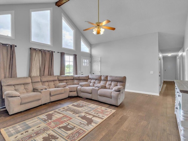 living room with a ceiling fan, wood finished floors, beam ceiling, high vaulted ceiling, and baseboards