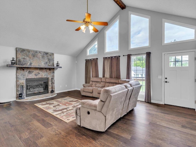 living room with high vaulted ceiling, a stone fireplace, dark wood-style flooring, ceiling fan, and plenty of natural light
