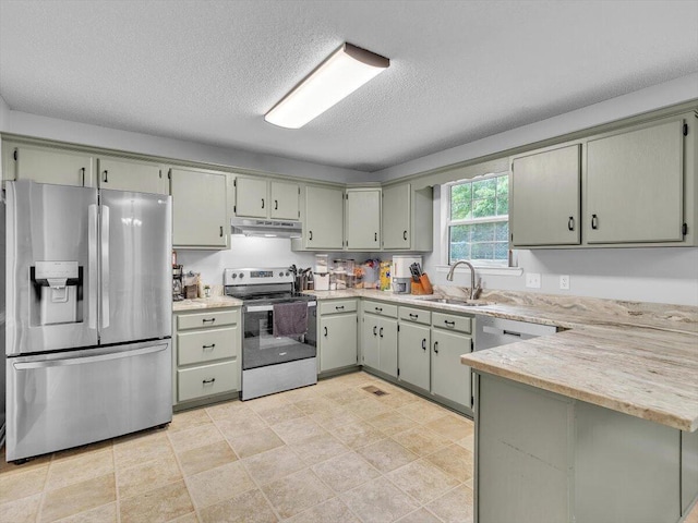 kitchen featuring stainless steel appliances, under cabinet range hood, a sink, a peninsula, and a textured ceiling