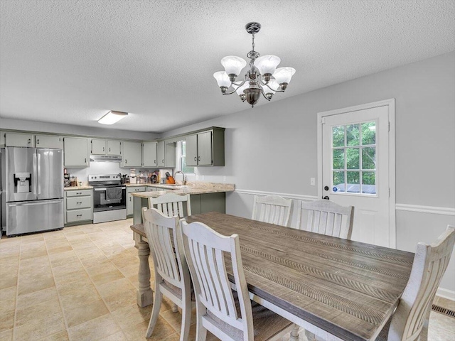 dining area with a chandelier and a textured ceiling