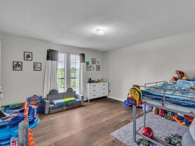 bedroom with wood finished floors and a textured ceiling