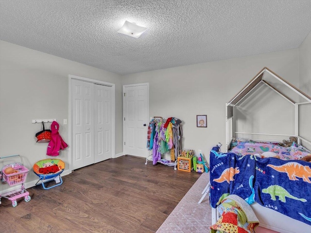 bedroom with wood finished floors, a textured ceiling, and a closet