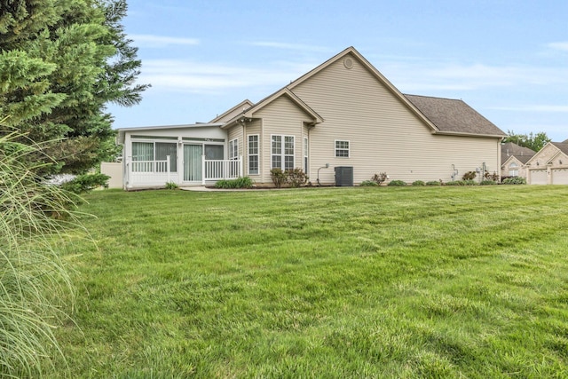 back of house with a yard, a sunroom, and central AC