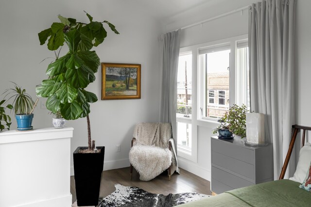 sitting room with plenty of natural light, wood finished floors, and baseboards
