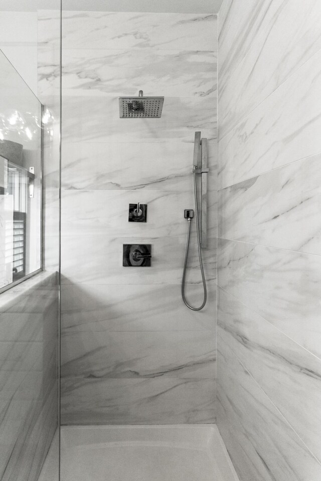 bathroom featuring a marble finish shower