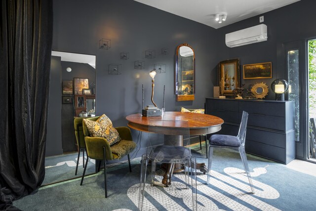 dining room with a wall unit AC and carpet flooring