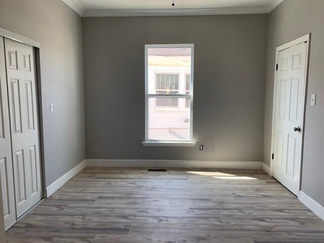3113 10th Ave, Chattanooga, TN 37407 - unfurnished bedroom with wood finished floors, ornamental molding, and a closet