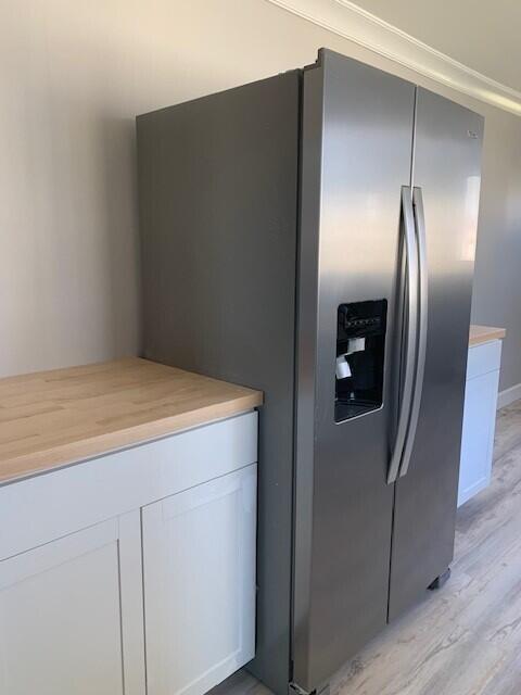 3113 10th Ave, Chattanooga, TN 37407 - kitchen with stainless steel fridge with ice dispenser, light wood-type flooring, light countertops, and white cabinets