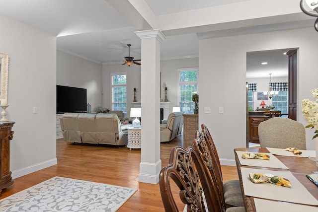 212 Smith St, Signal Mountain, TN 37377 - dining room featuring ornate columns, ceiling fan, light wood-style flooring, a chandelier, and baseboards