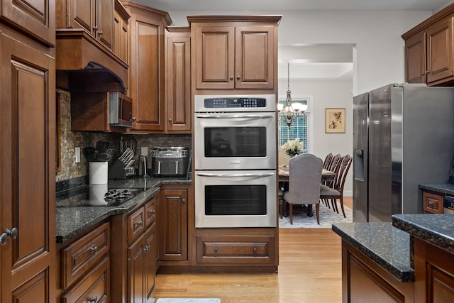 212 Smith St, Signal Mountain, TN 37377 - kitchen featuring appliances with stainless steel finishes, light wood-style flooring, a chandelier, decorative backsplash, and dark stone counters