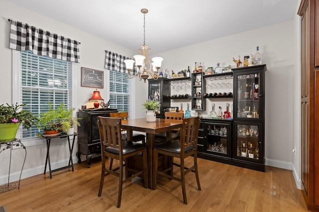 212 Smith St, Signal Mountain, TN 37377 - dining area with a chandelier, light wood finished floors, a bar, and baseboards