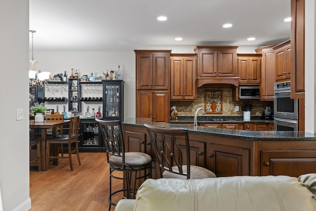 212 Smith St, Signal Mountain, TN 37377 - kitchen featuring appliances with stainless steel finishes, light wood-type flooring, backsplash, recessed lighting, and dark stone countertops