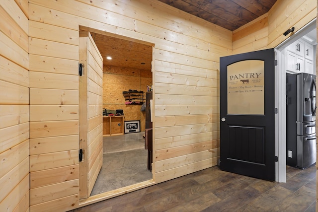 interior space featuring wooden walls, wood ceiling, and dark wood finished floors