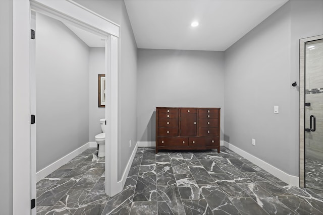 foyer entrance with baseboards, dark marble finish flooring, and recessed lighting