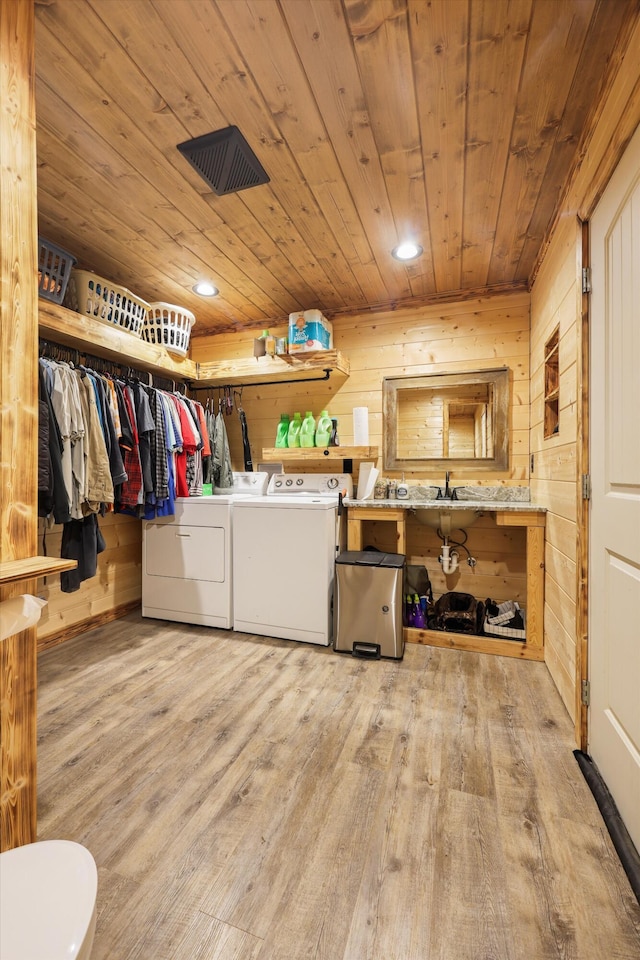 washroom with wooden ceiling, washer and clothes dryer, wood finished floors, wood walls, and recessed lighting