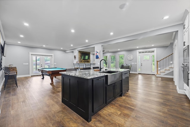kitchen featuring dark cabinets, open floor plan, french doors, stainless steel appliances, and a sink